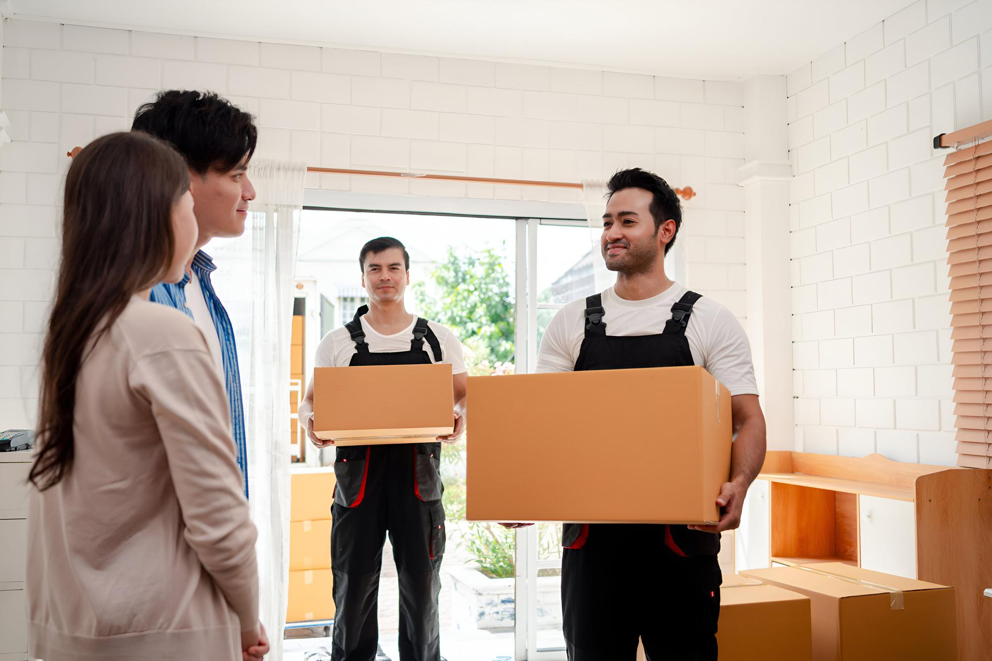 Una pareja asiática comproba mientras descarga cajas